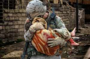 Photo of US soldier carrying an Iraqi girl wounded in an SVBIED attack