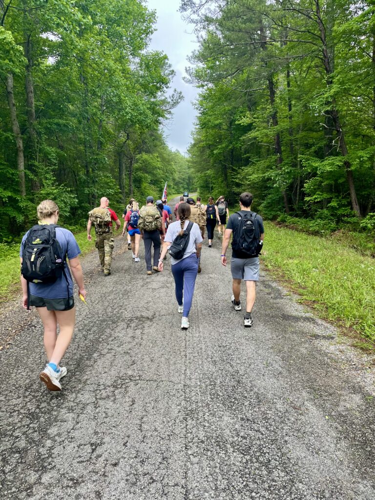 group of people rucking with weighted backpacks to honor SrA Mark Forester