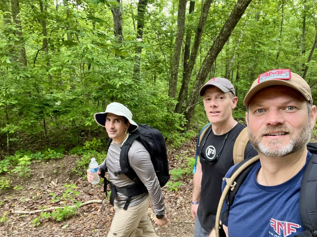 men rucking with weighted backpack for fitness and mental toughness