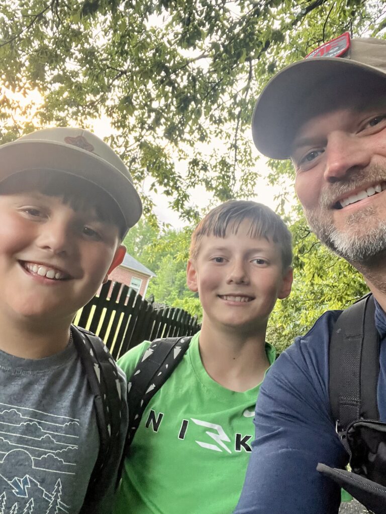 father and sons rucking in nature