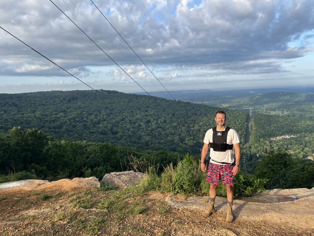 male with goruck achilles weight vest on top of mountain